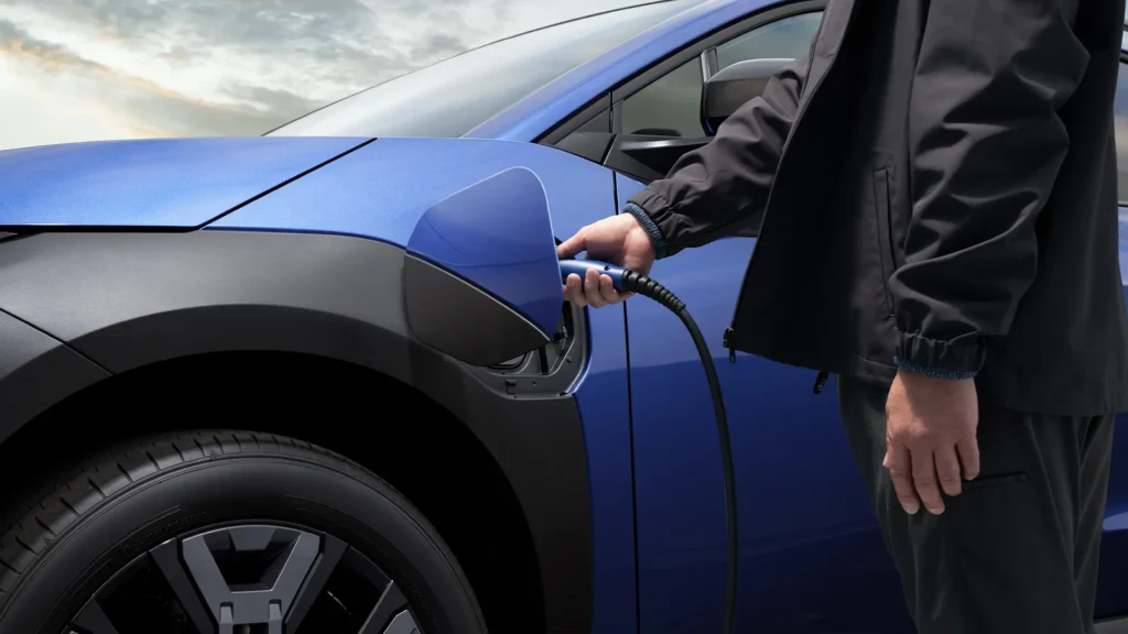 Person lader en blå elbil.